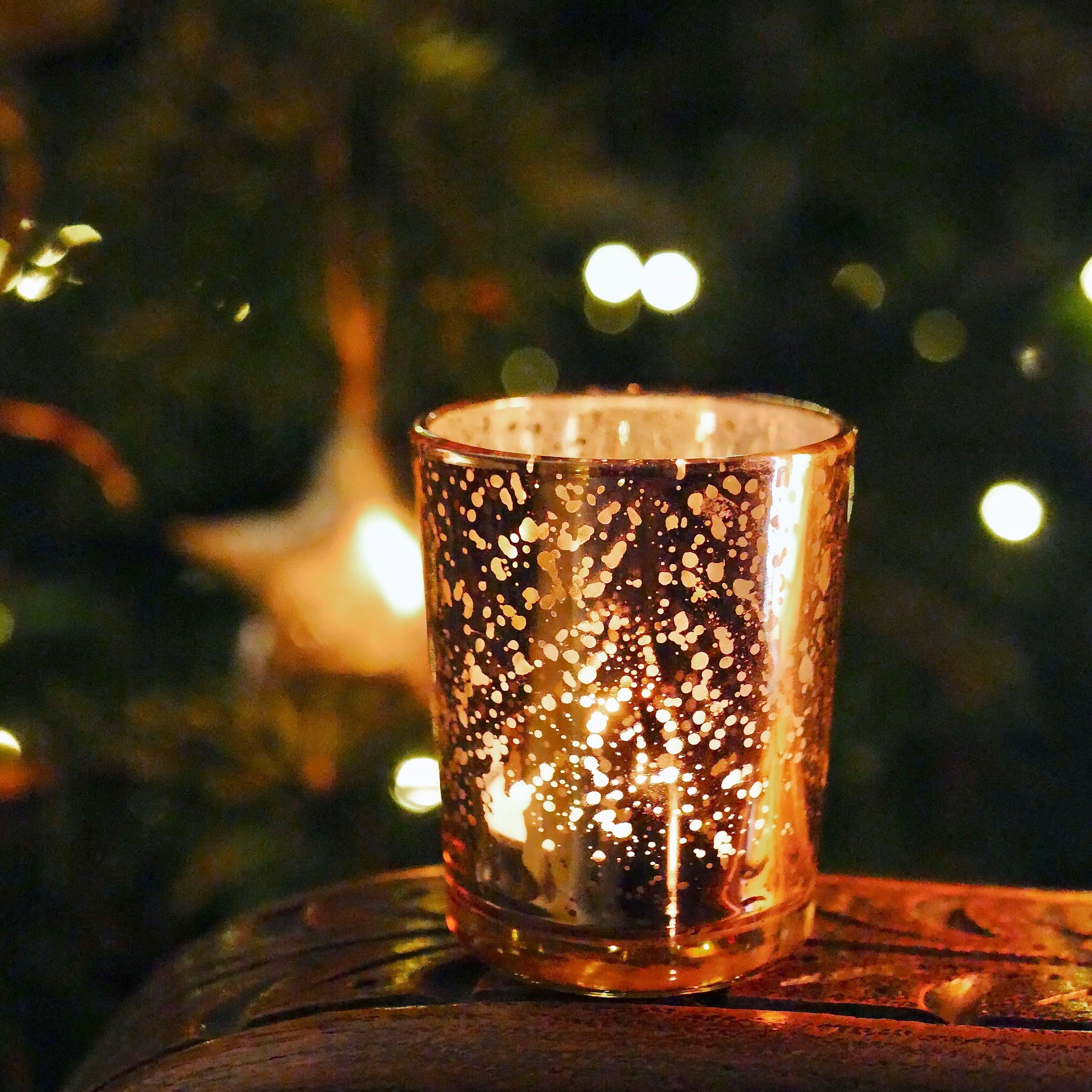 Rose-gold tealight holder votive in front of Christmas tree